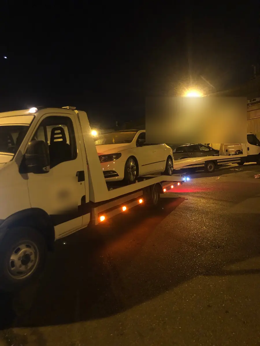 Gece sanayi sokağında kayar kasa üzerinde beyaz sedan